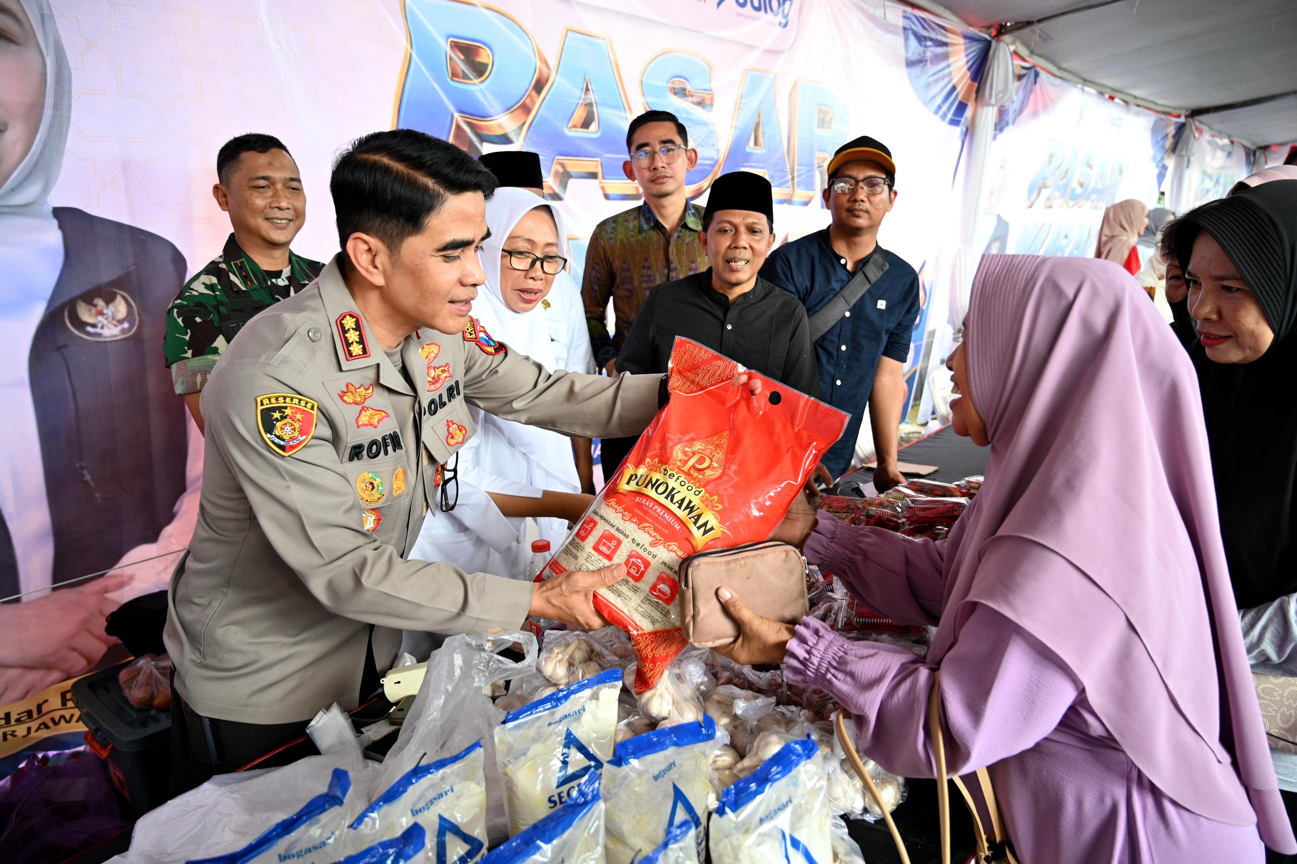 HARGA TERJANGKAU: Kapolresta Kombespol Rofiq Ripto Himawan didampingi Imam Maskun, Dandim, dan Kadiskop-UMP menyerahkan beras kepada warga di arena pasar murah KMP Tukangkayu.
