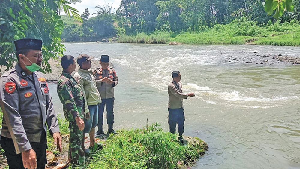 Anggota Polsek dan Koramil Glenmore melakukan pencarian bocah berusia 8 tahun berinisial AA asal Dusun Pegundangan, Desa Karangharjo, Glenmore yang hanyut terbawa arus Sungai Kalibaru, Jumat (6/3).