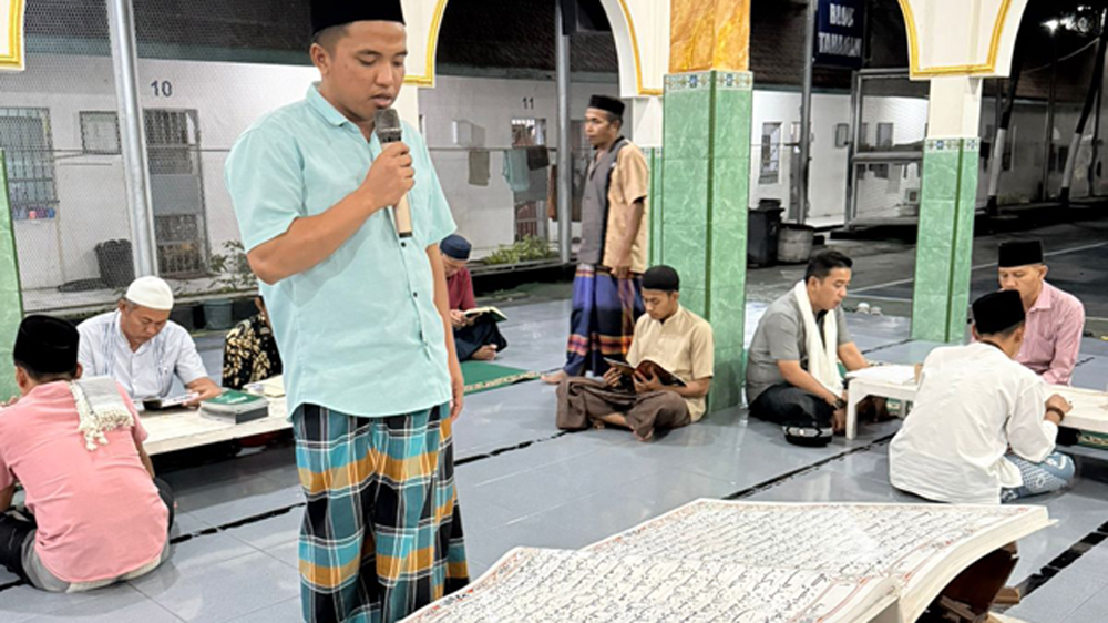 Sejumlah warga binaan tadarus menggunakan Al-Qur'an ukuran super jumbo di Masjid Lapas Banyuwangi, Kamis (5/3).