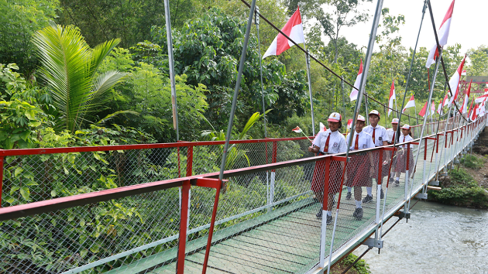 RIANG: Sejumlah siswa melintas di Jembatan Perintis Garuda di Desa Seneporejo, Kecamatan Siliragung, Senin (9/3).
