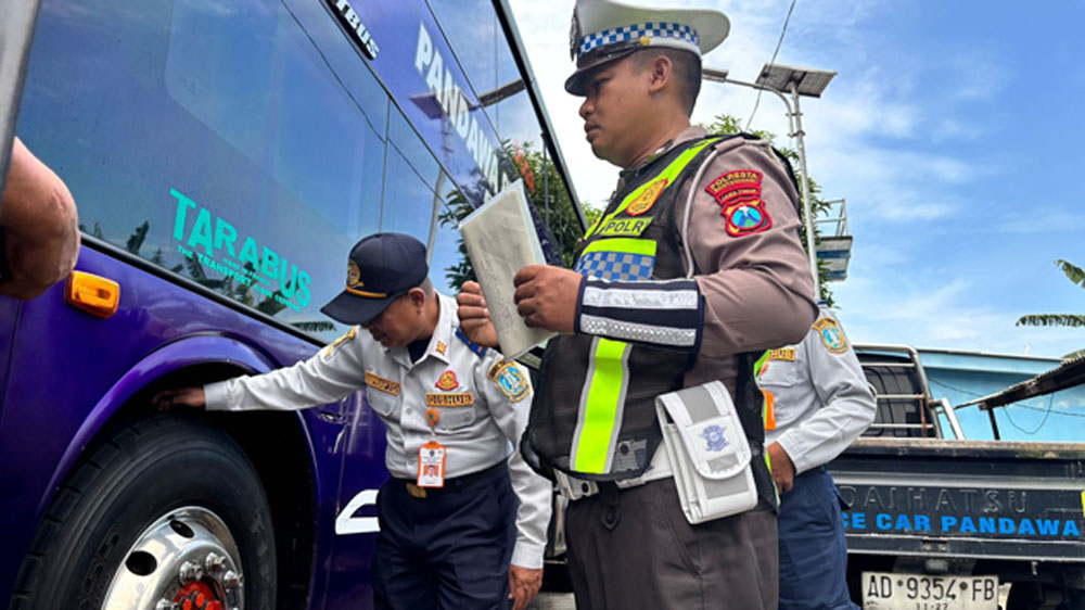 PEMERIKSAAN RUTIN: Personel Satlantas dan Dishub Banyuwangi memeriksa kondisi roda bus di Terminal Brawijaya, Selasa (10/3).