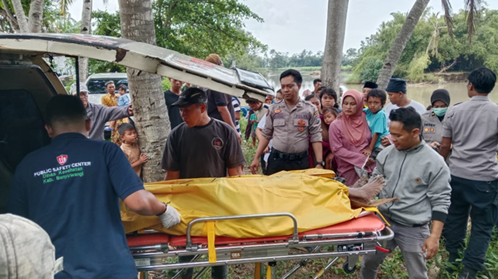 Personel Polsek Kabat mengevakuasi mayat menuju mobil ambulans di Pantai Kedung Derus, Desa Pondoknongko, Kecamatan Kabat, Minggu (8/3).