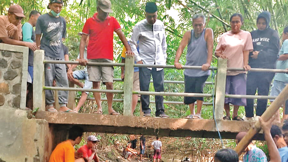 Keluarga bersama dengan warga sekitar mencari bocah yang tenggelam di sungai Dusun Petahunan, Desa Jajag, Kecamatan Gambiran, Selasa (10/3).