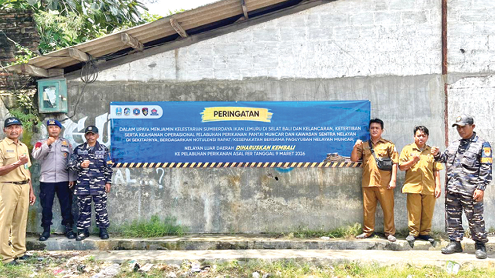 Petugas gabungan memasang spanduk peringatan kepada nelayan asal luar Muncar agar kembali ke pelabuhan perikanan asal per 9 Maret.