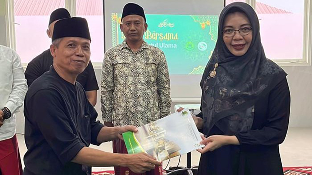 Ketua PCNU Banyuwangi KH Ahmad Turmudzi menyerahkan SK Yayasan RSNU Banyuwangi tentang perpanjangan jabatan direktur masa khidmat 2026-2029 kepada dr Ika Rahayu Susanti.