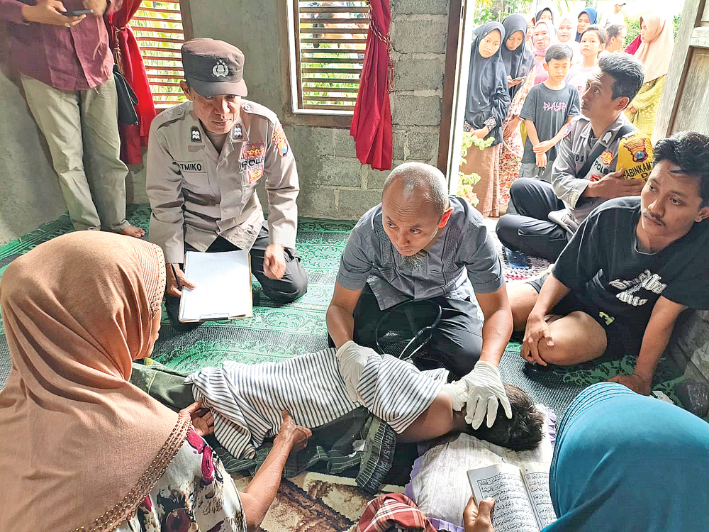 Anggota Polsek Bangorejo melakukan pemeriksaan korban di rumah duka Desa Tegalrejo, Kecamatan Tegalsari, pada Rabu sore (11/3).