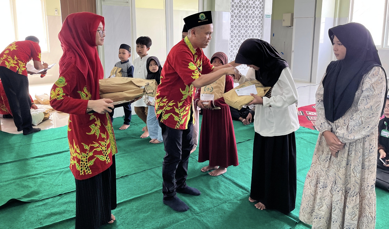 Prosesi penyerahan santunan pada anak yatim piatu.