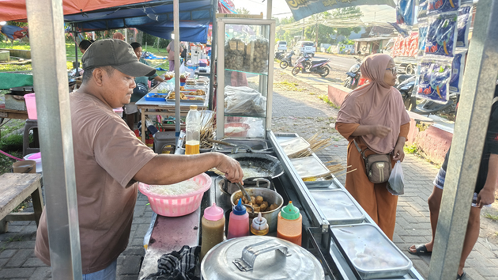 MENGAIS REZEKI: Pedagang takjil di RTH Blambangan, Kecamatan Muncar melayani pembeli, Kamis (12/3).