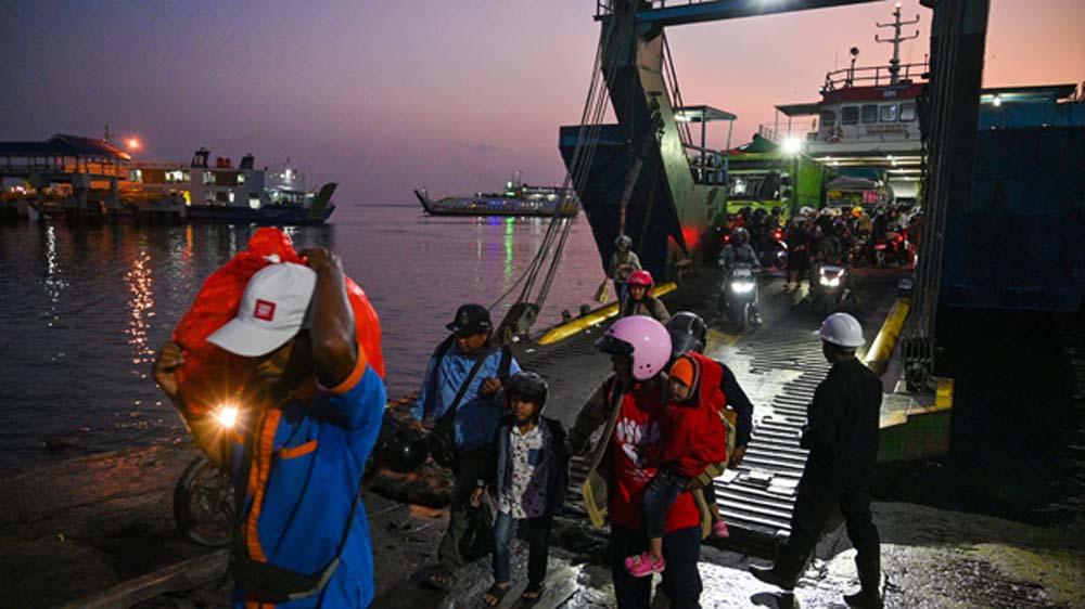 PASCA SANDAR: Pemudik pejalan kaki keluar dari kapal di Pelabuhan Ketapang, Minggu pagi (15/3).