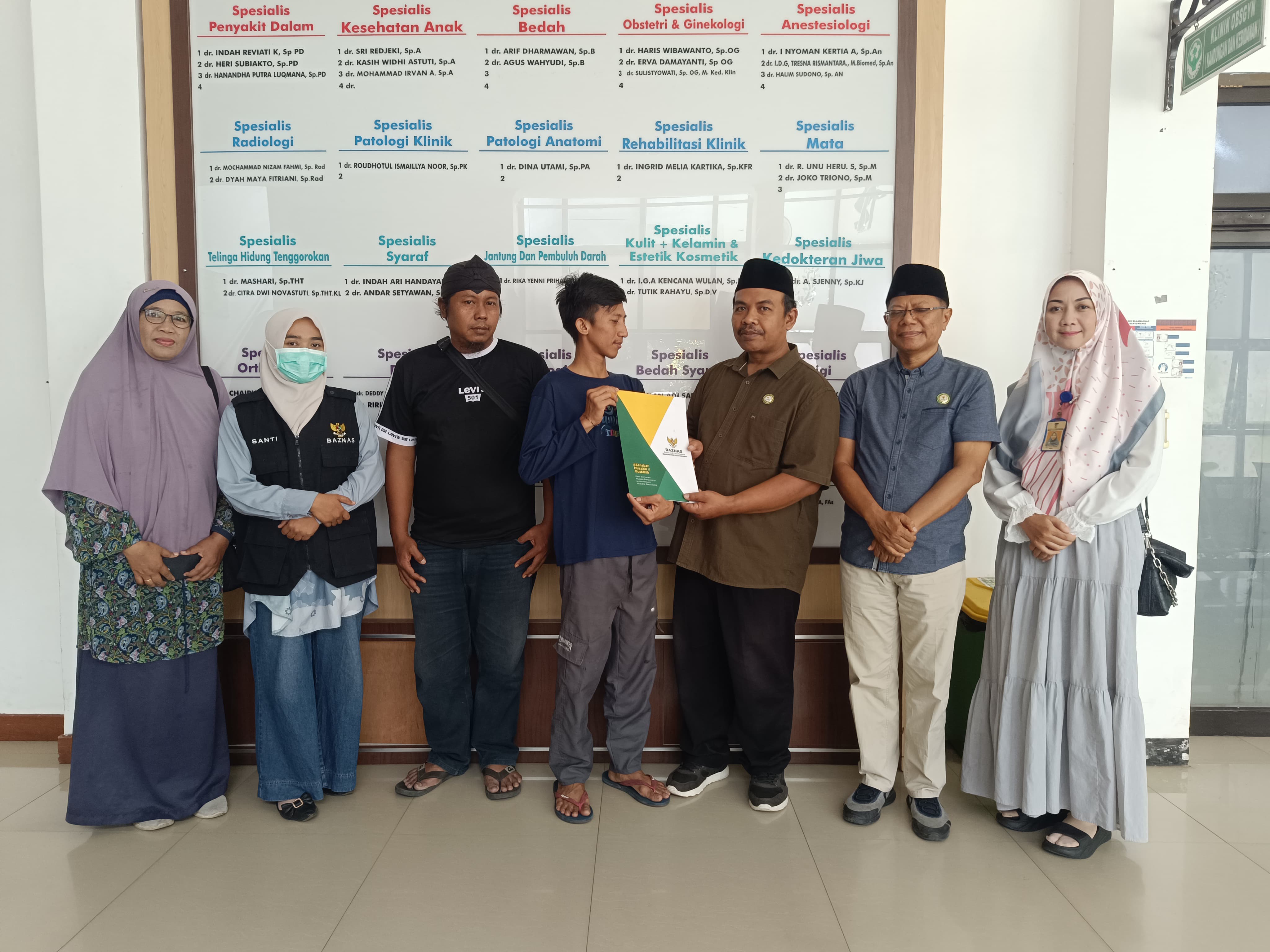 Wakil Ketua Bidang Distribusi Baznas Kabupaten Banyuwangi Nanang Kairurozik didampingi Ketua Baznas Dwi Yanto dan perwakilan UPZ Kecamatan Banyuwangi menyerahkan bantuan biaya pengobatan ke Roimartin.