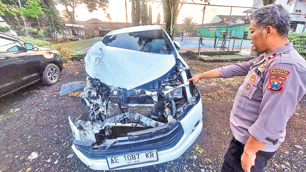 Anggota Unit Lantas Polsek Genteng saat menunjukkan kondisi mobil Toyota Innova Reborn nopol AE 1087 KR yang terlibat kecelakaan di Jalan Raya Desa Setail, Kecamatan Genteng, Minggu dini hari (15/3).