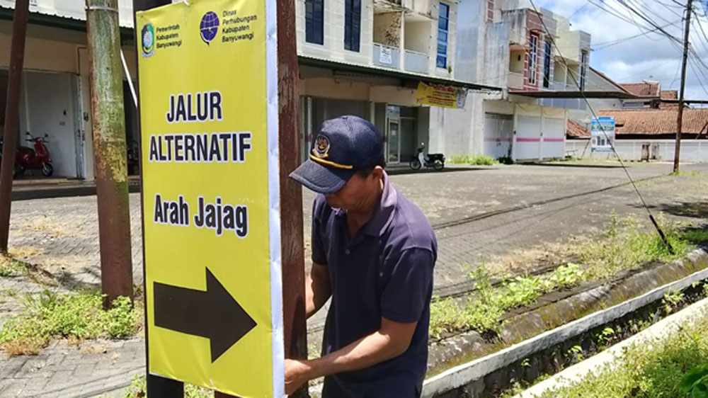 RAMBU TAMBAHAN: Petugas Dishub Banyuwangi memasang rambu jalur alternatif di dua titik, Senin (16/3).