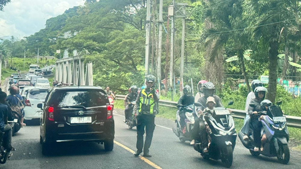 Personel Turjawali Satlantas Polresta Banyuwangi mengatur kepadatan arus lalu lintas di Jembatan Sasak Tambong, Kecamatan Kabat, Selasa (24/3).
