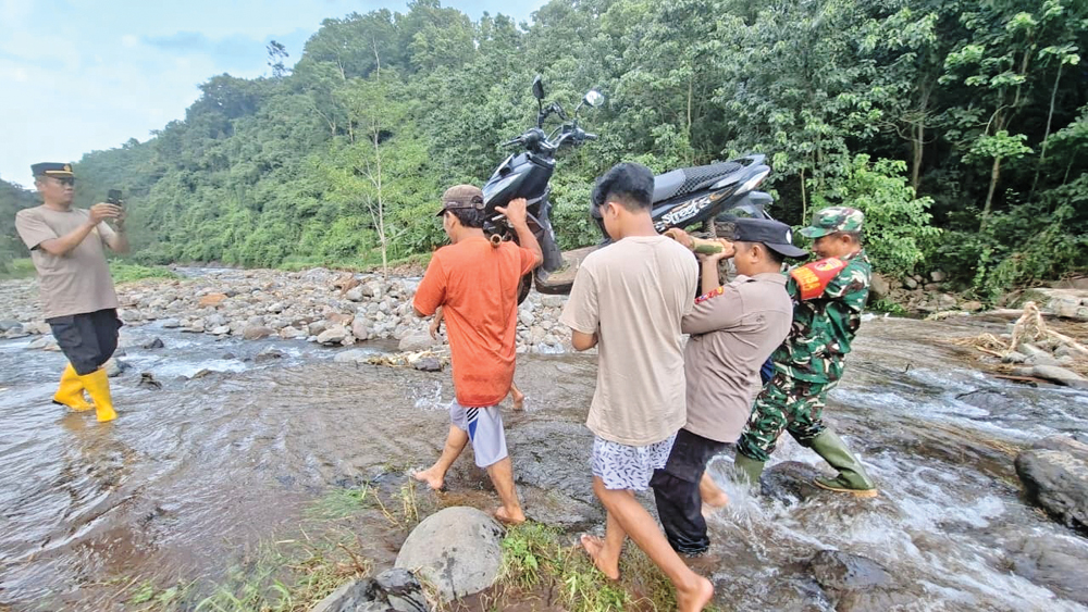 Warga melintasi jembatan yang putus di Desa Wringinanom, Kecamatan Jatibanteng, beberapa hari lalu. Jembatan tersebut putus akibat diterjang banjir pada Januari lalu.