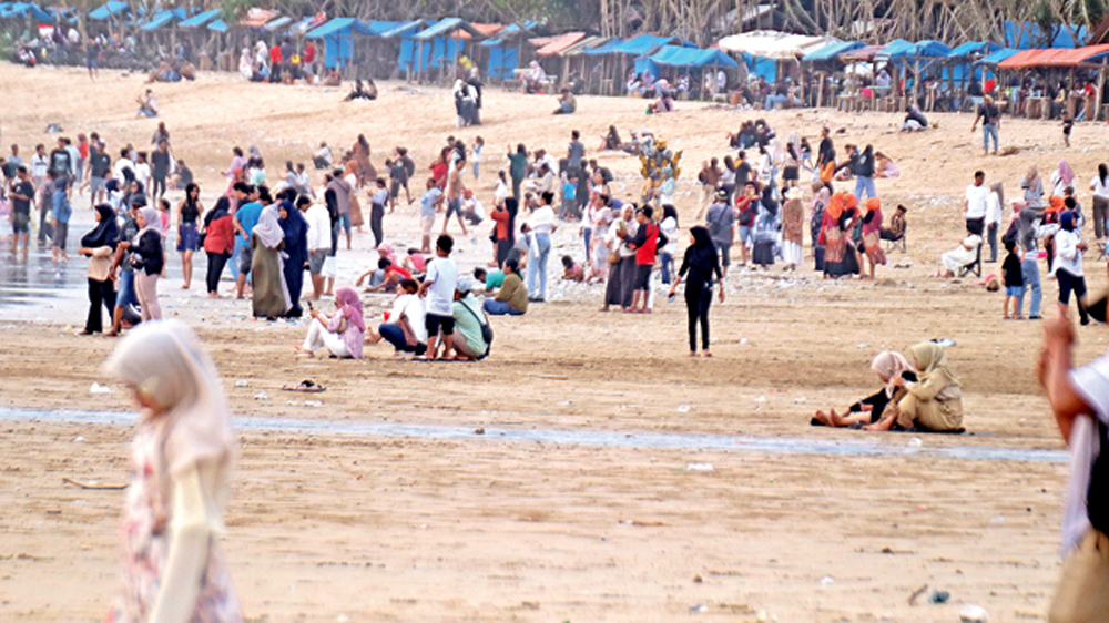 Ribuan pengunjung memadati Pantai Pulau Merah (PM) di Dusun Pancer, Desa Sumberagung, Kecamatan Pesanggaran saat libur Lebaran, Senin (23/3).