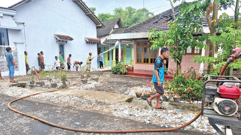 Petugas Damkarmat Sektor Srono bersama warga bahu membahu memadamkan api di rumah Misidi warga Desa Blambangan, Kecamatan Muncar, pada Minggu (22/3).