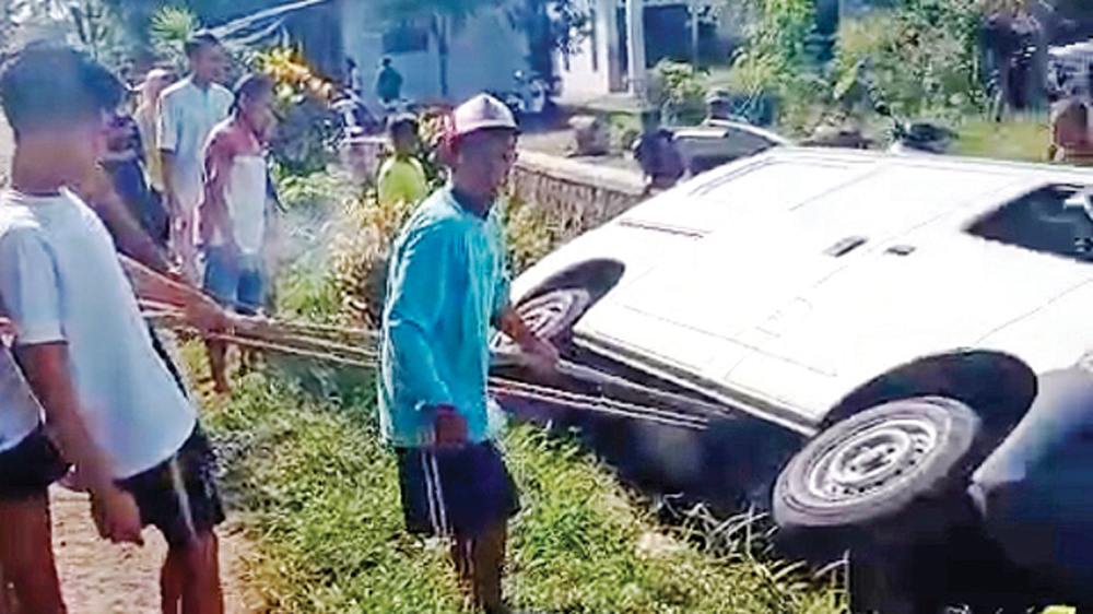 DITARIK PAKAI TALI: Warga Desa Kradenan, Kecamatan Purwoharjo mengevakuasi mobil Gran Max masuk parit, Rabu (25/3).