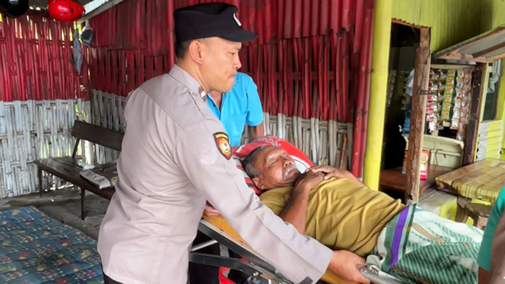 Petugas gabungan dari Pemdes Genteng Wetan dan Polsek Genteng mengevakuasi kakek tunawisma ke rumah sakit, Selasa (24/3).