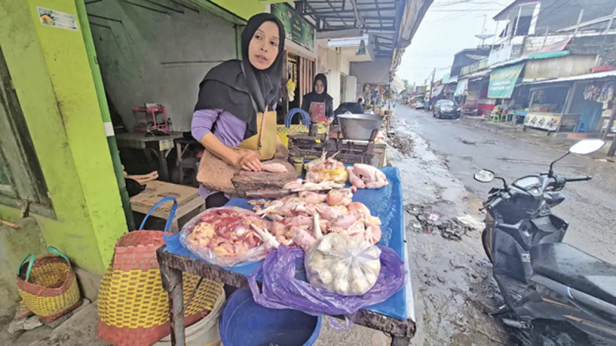 Pedagang di Pasar Dusun Panjen, Desa Jambewangi, Kecamatan Sempu memotong daging ayam untuk dijual ke pembeli, Rabu (25/3). (Salis Ali/Radar Banyuwangi)