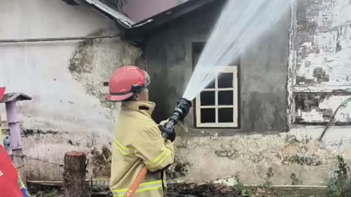 Petugas Damkarmat  memadamkan rumah warga yang terbakar di di Jalan Jaksa Agung Suprapto, Kelurahan Penganjuran,  Rabu (25/3). (Damkarmat Banyuwangi)
