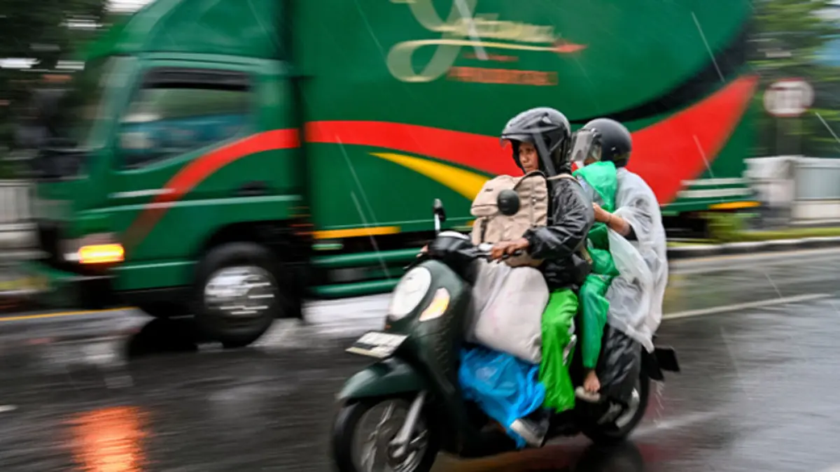 Seorang pemudik bersepeda motor membonceng istri dan anaknya menuju Pelabuhan Ketapang. (Ramada Kusuma/Radar Banyuwangi)