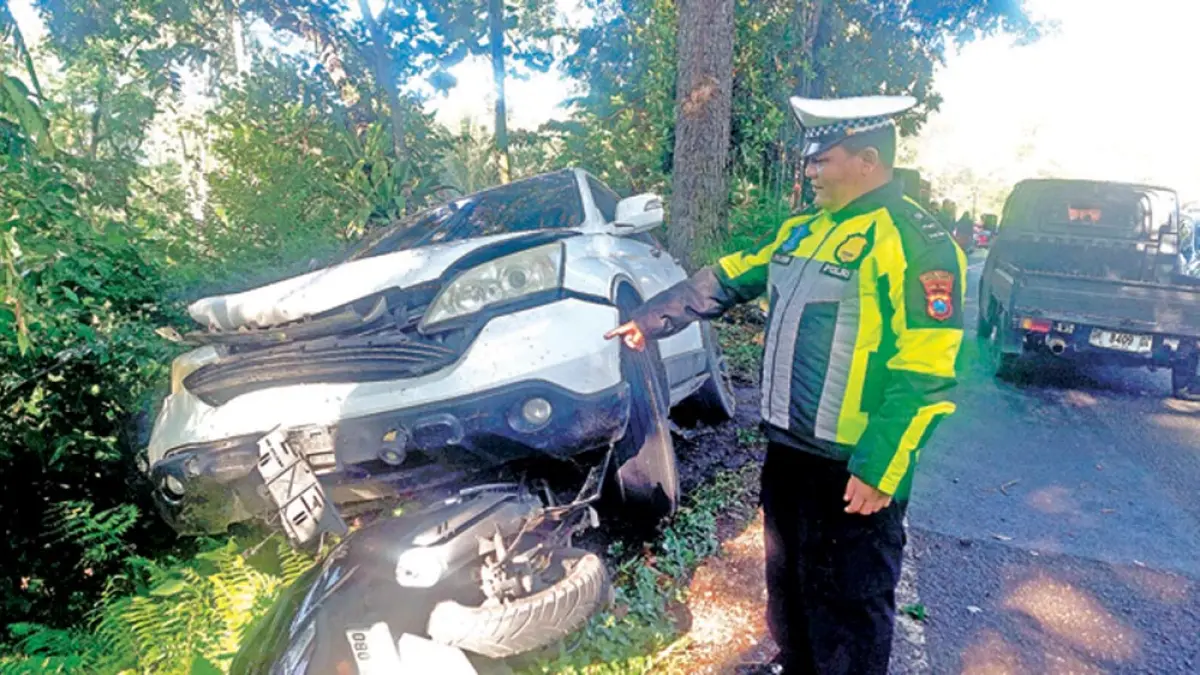 Kanitlantas Polsek Kalibaru Aipda Aries Prasetyanto menunjukkan kondisi kendaraan Honda CRV warna putih nopol  DK 1106 FBC yang terlibat kecelakaan di Jalur Gumitir, Minggu (29/3). (Aries for Radar Banyuwangi)