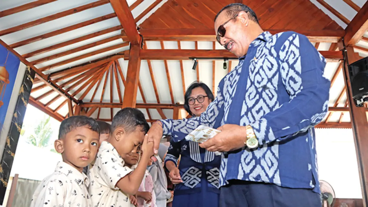 Plt Kepala Smadatara Genteng I Ketut Renen membagikan angpao kepada anak-anak karyawan pada kegiatan halalbihalal di SMAN 2 Taruna Bhayangkara pada Sabtu (28/3). (Salis Ali/Radar Banyuwangi)