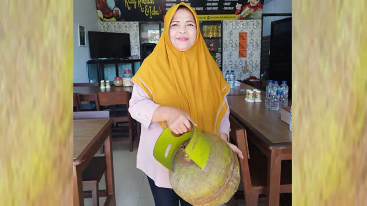 MENGELUH: Pemilik warung makan, Mariyam menunjukkan gas melon miliknya dalam kondisi kosong, Selasa (31/3). (Bagus Rio/Radar Banyuwangi)