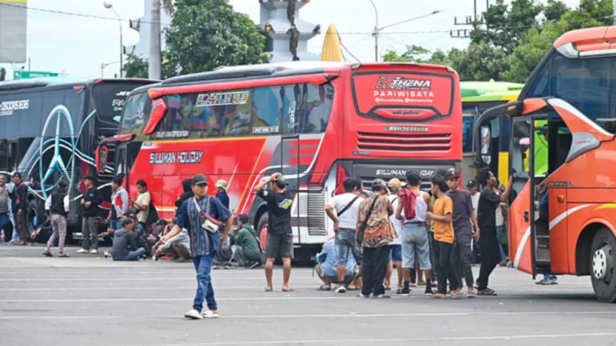 RUGI WAKTU DAN BIAYA: Kru bus menunggu giliran masuk kapal sembari tidur-tiduran di dekat parkiran Pelabuhan ASDP ketapang, Selasa (31/3). (Ramada Kusuma/Radar Banyuwangi)