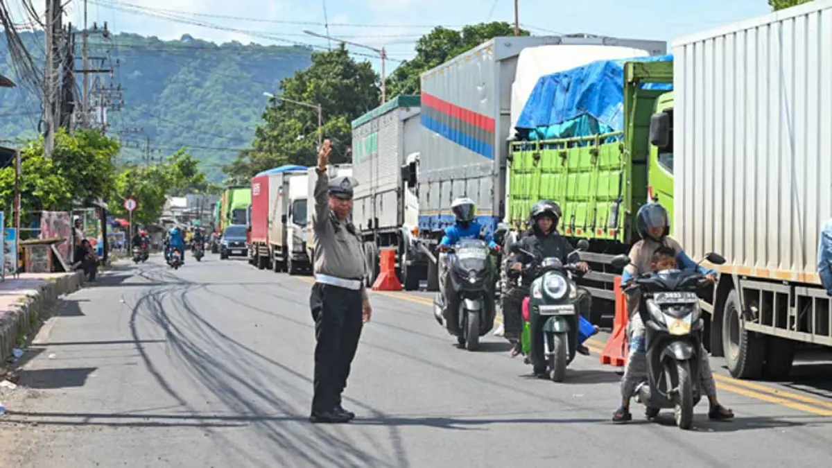 URAI KEMACETAN: Anggota Satlantas Polres Banyuwangi mengatur kemacetan arus lalu lintas di Jalan Lingkar Ketapang menggunakan pengeras suara, Selasa (31/3). (Hendro for Radar Banyuwangi)