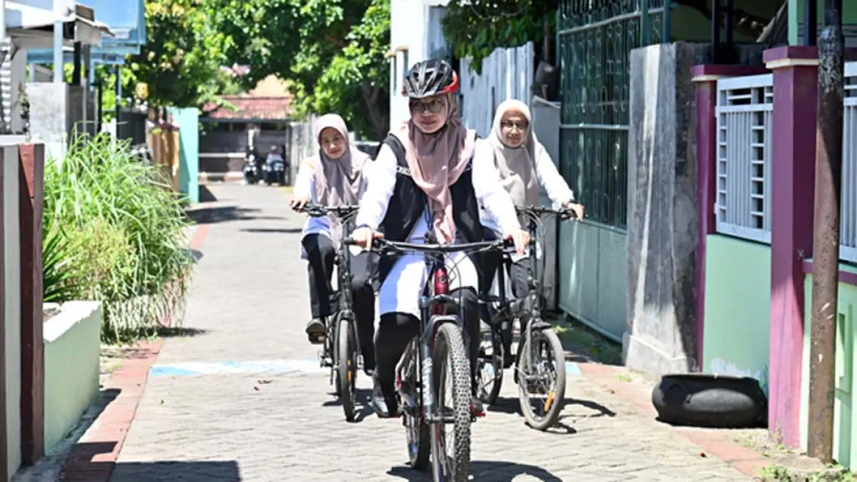 SUSURI JALAN KAMPUNG: Bupati Ipuk Fiestiandani dikawal Sekretaris Diskominfo dan Pesandian Rahmawati Setyoardini naik sepeda gunung dari Baluk menuju kantor Pemkab Banyuwangi, Rabu (1/4). (Ramada Kusuma/Radar Banyuwangi)