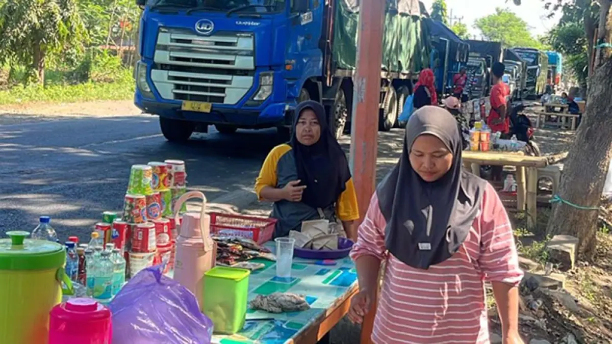 DAPAT BERKAH: Para penjual makanan yang biasanya mangkal di dalam area GWD, kini berjualan di pinggir jalan untuk melayani pengendara. (Ramada Kusuma/Radar Banyuwangi)