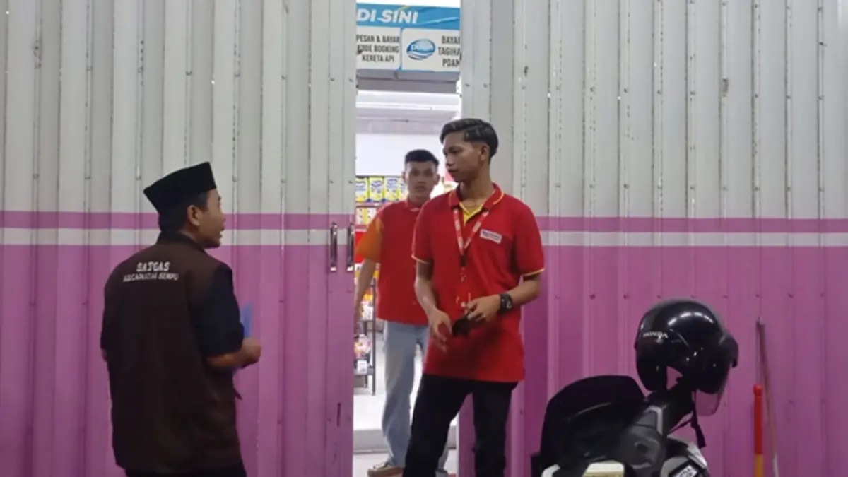 PENERTIBAN: Petugas menyebar selebaran informasi aturan jam operasional bagi toko swalayan dan ritel modern, Kamis (2/4). (Salis Ali/Radar Banyuwangi)