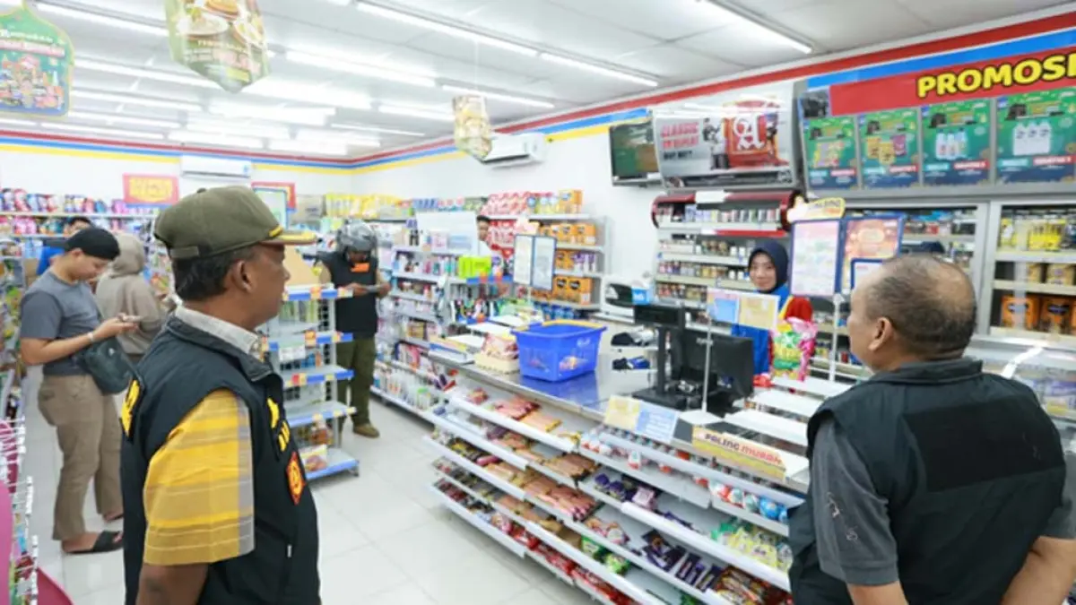 RAZIA: Kasatpol PP Banyuwangi Yoppy Bayu Irawan bersama personelnya menegur toko modern di Jalan Banterang, Kampung Melayu, Banyuwangi, Rabu malam (1/4). (Bagus Rio/Radar Banyuwangi)