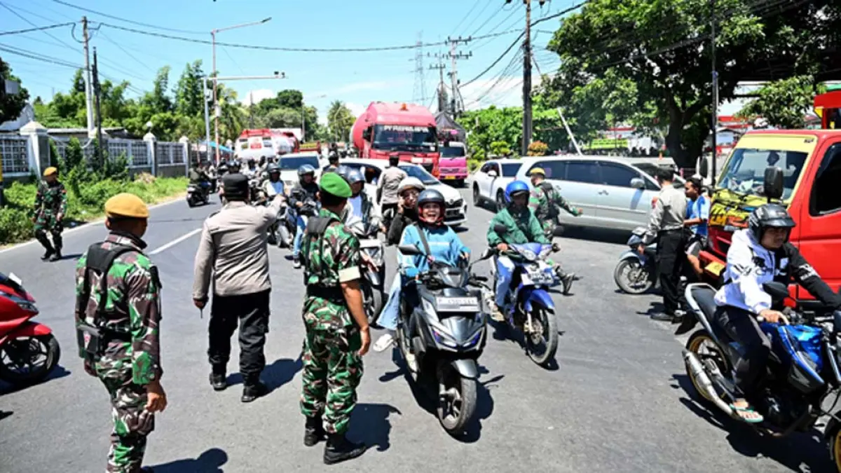 URAI KEMACETAN: Personel TNI dan aparat kepolisian mengatur arus lalu lintas di pertigaan SPBU Farly, Desa Ketapang, Kecamatan Kalipuro, Kamis (2/4). (Ramada Kusuma/Radar Banyuwangi)