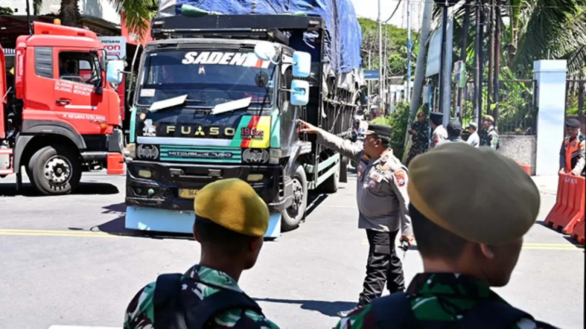 URSAI KEMACETAN: Personel TNI dan aparat kepolisian mengatur arus lalu lintas di pertigaan SPBU Farly, Desa Ketapang, Kecamatan Kalipuro, Kamis (2/4). (Ramada Kusuma/Radar Banyuwangi)
