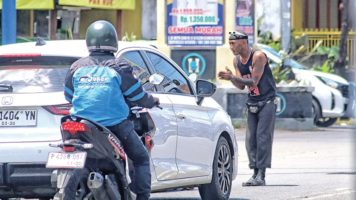 MERESAHKAN: Anak punk mengamen di di simpang tiga lampu lalu lintas Jalan Gajah Mada, Desa Gentengwetan, Kecamatan Genteng, Kamis (2/4). (Salis Ali/Radar Banyuwangi)
