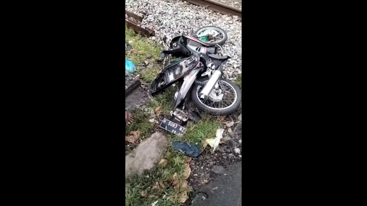 Pengendara motor tertemper Kereta Api Harina di Semarang setelah menerobos palang perlintasan. (Tangkapan Layar)