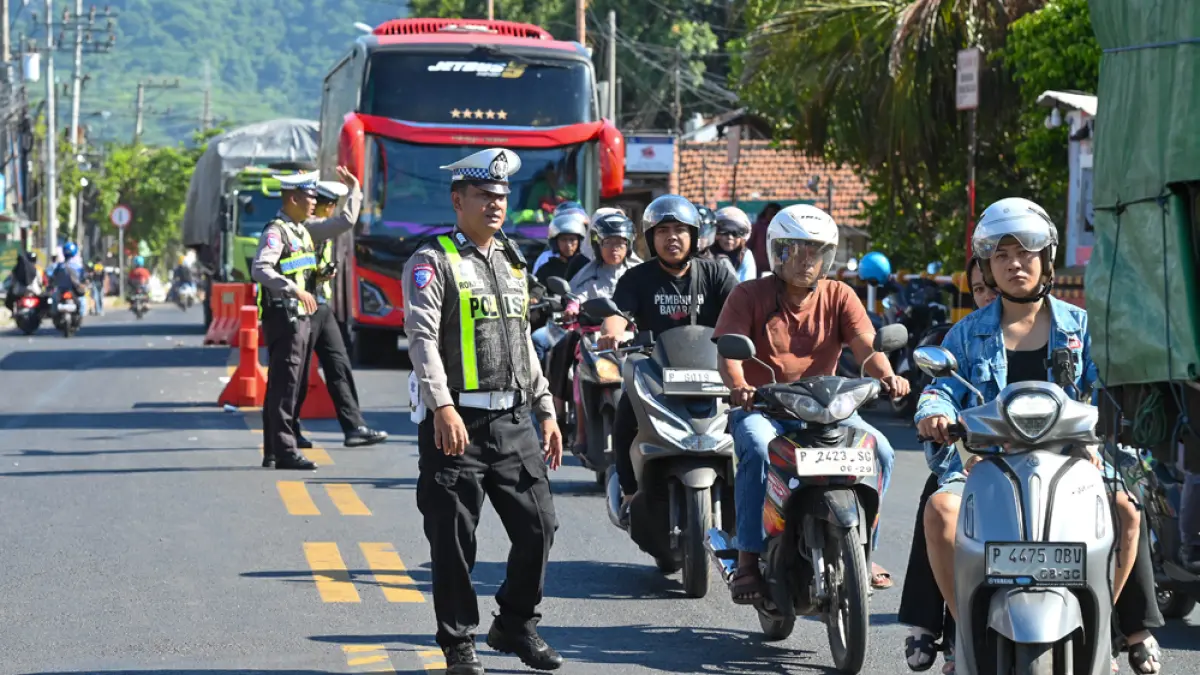 TAK LAGI MACET: Aparat kepolisian mengatur arus lalu lintas di sebelah utara pintu masuk menuju Pelabuhan ASDP Ketapang, Sabtu (4/4). (Ramada Kusuma/Radar Banyuwangi)
