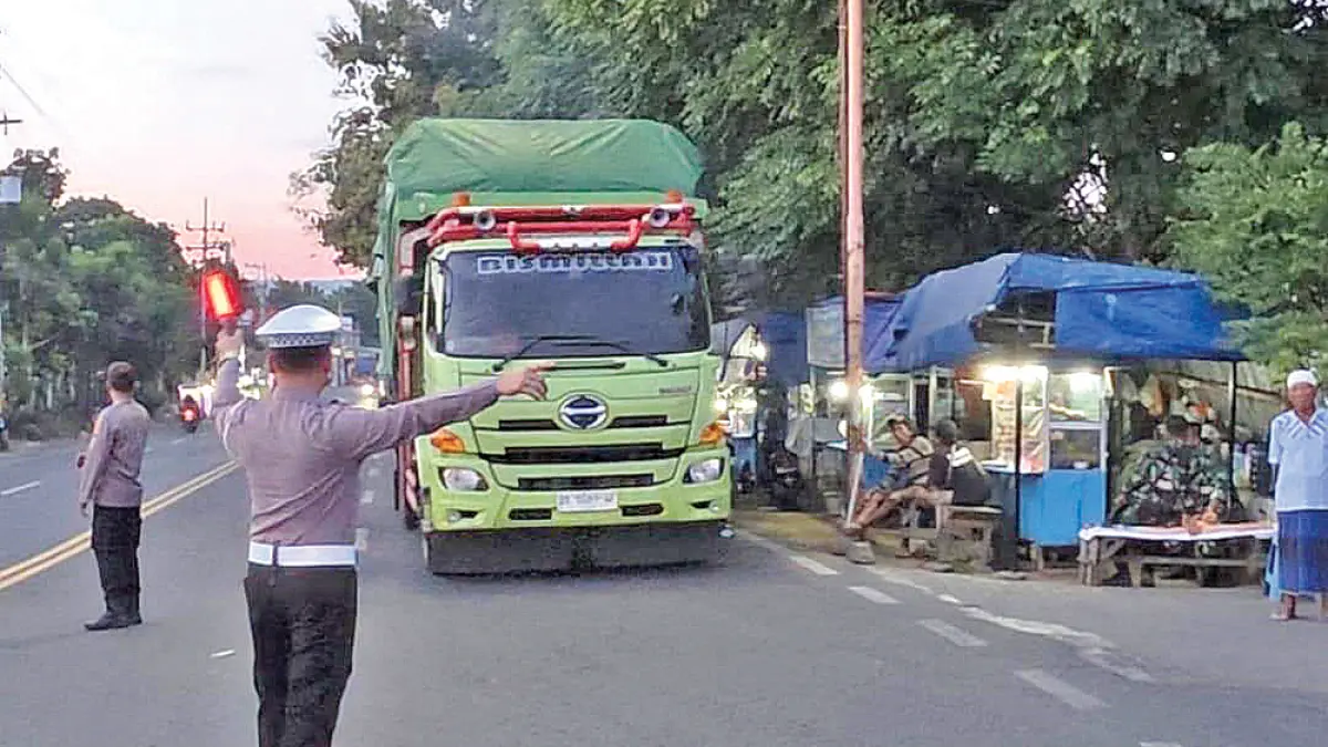 CEGAH PENUMPUKAN: Personel Polresta Banyuwangi mengarahkan kendaraan bertonase besar menuju kantong parkir di kawasan Bulusan. (Humas Polresta Banyuwangi)