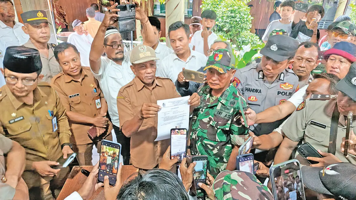 PERNYATAAN BERMATRAI: Kades Sukojati Untung Suripno membacakan surat pengunduran diri di hadapan ratusan warga, Senin (6/4). (Zamrozi Wahyu/Radar Banyuwangi)