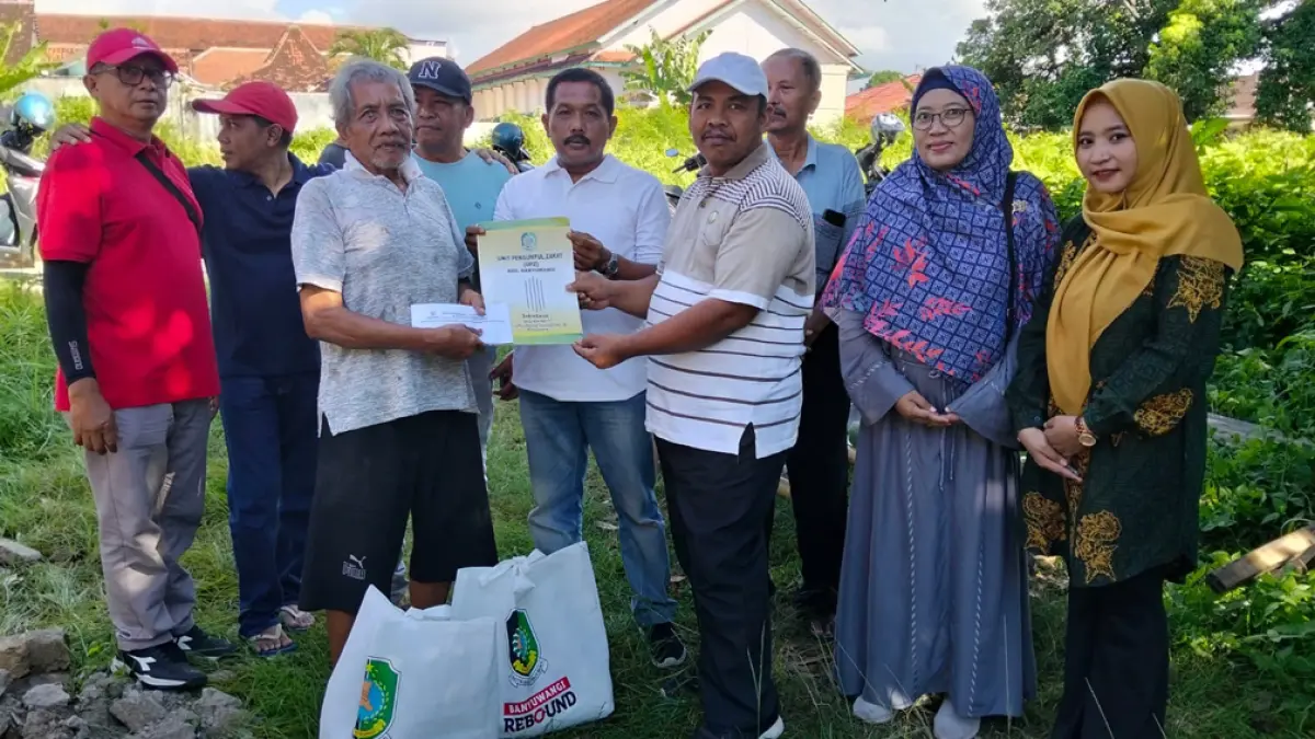 SIMBOLIS: Wakil Ketua Bidang Distribusi Baznas Banyuwangi Nanang Khairurozik menyerahkan bantuan pemindahan dan renovasi rumah kepada Ismanto disaksikan jajaran Forpimka Banyuwangi pada Sabtu pagi (4/4). (Baznas Banyuwangi)