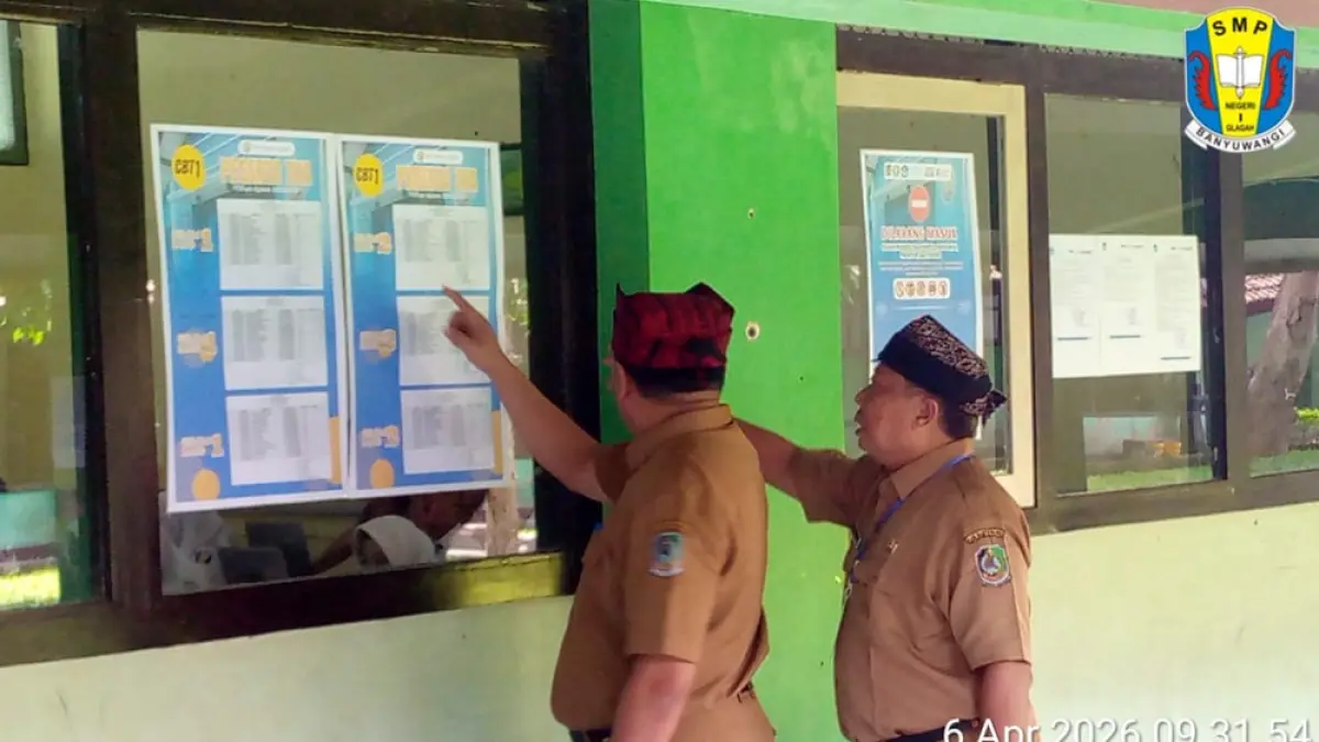 DILARANG MASUK: Plt Kadispendik Alfian dan Kepala SMPN 2 Glagah Dardiri melihat denah pengaturan ruang TKA, Senin (6/4). (Dardiri for Radar Banyuwangi)