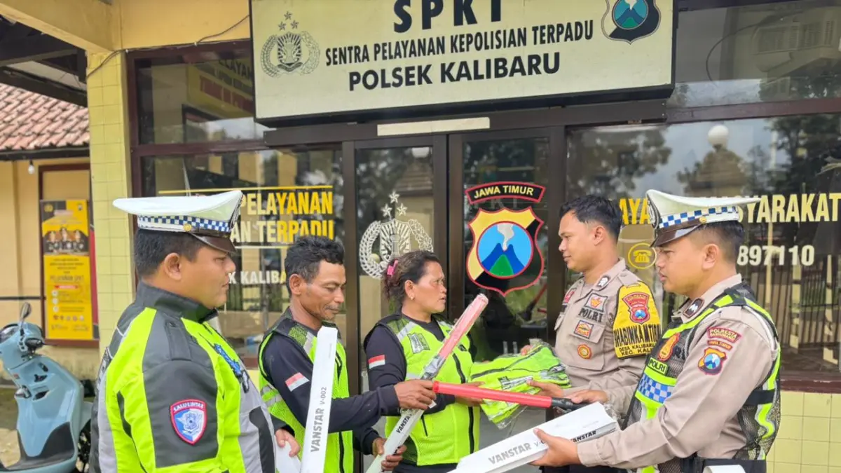 Personel Satlantas Kalibaru menyerahkan rompi dan senter Lantas kepada relawan di jalur Gumitir, Kamis (9/4/2026).
