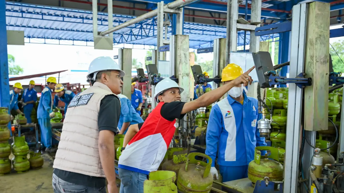 RAMADA KUSUMA/RABA
TIDAK TEMUKAN PENGURANGAN: Kanit Pidus Polresta Banyuwnagi Ipda Asmal Rahadian (pakai rompi) mengecek proses pengisian elpiji melon di SPBE Rogojampi, Kamis sore kemarin (9/4).