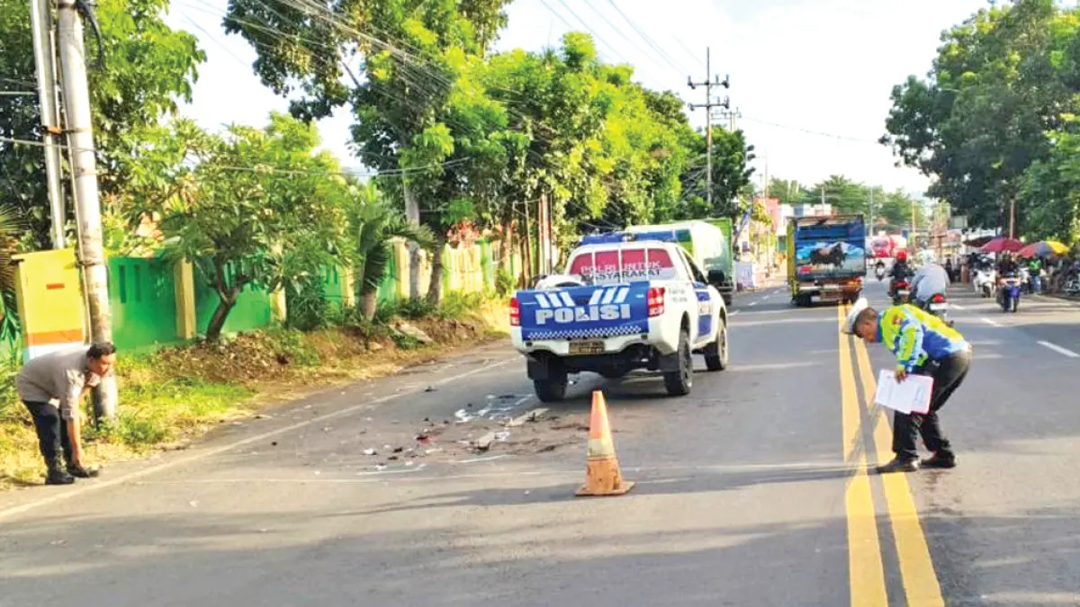 LANGSUNG JATUH: Anggota Satlantas Polresta Banyuwangi melakukan oleh TKP lokasi kecelakaan di dekat tempat pemakaman Desa Ketapang, Kecamatan Kalipuro, Minggu (12/4). (Satlantas Polresta Banyuwangi)