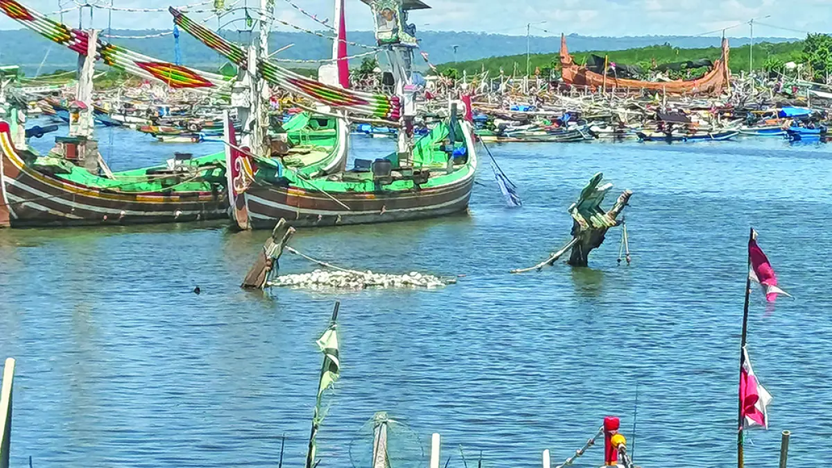 TENGGELAM: Bangkai perahu nelayan mangkrak di kolam Pelabuhan Muncar mengganggu pergerakan nelayan, Jumat (10/4). (Zamrozi Wahyu/Radar Banyuwangi)