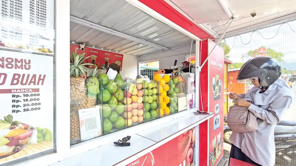 HARGA MELAMBUNG: Pemilik kedai jus di Jalan Raya Kalisetail, Desa/Kecamatan Sempu sangat terdampak kenaikan harga plastik kemasan. (Salis Ali/Radar Banyuwangi)