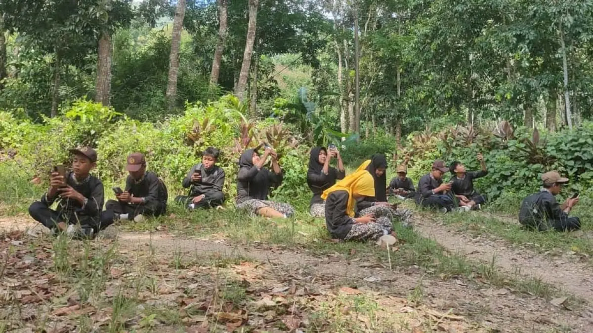 Siswa SDN 2 Sarongan Sukamade Banyuwangi rela naik bukit dan masuk hutan demi sinyal untuk try out TKA online Radar Banyuwangi. (Gerda Sukarno/Radar Banyuwangi)