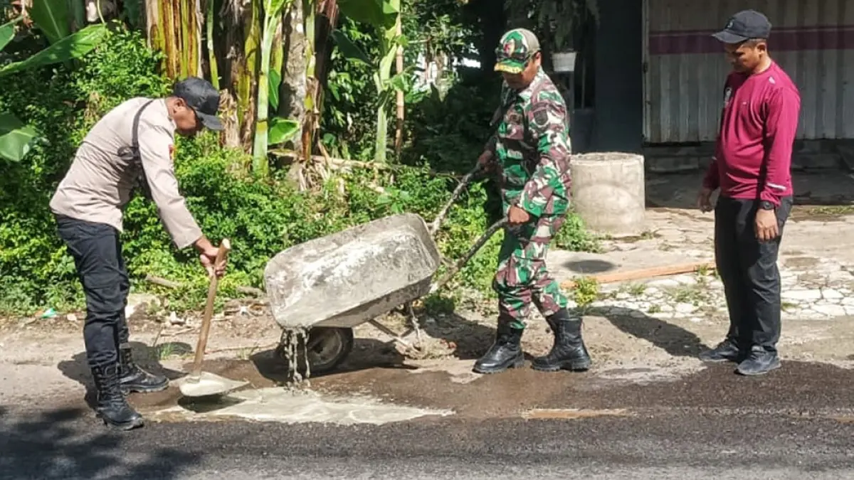 TANDANG BARENG: Petugas gabungan tambal ruas jalan berlubang di Dusun Blokagung, Desa Karangdoro, Kecamatan Tegalsari, Selasa (14/4). (Salis Ali/Radar Banyuwangi)